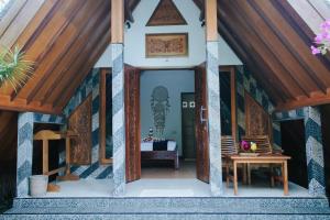 a small house with a wooden ceiling and a table at Lucy's Garden Hotel in Gili Air