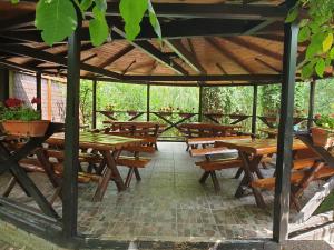 a wooden pavilion with wooden tables and benches at Daiana Residence Cabane in Turda