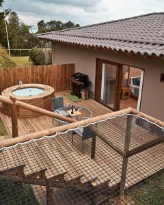 una terraza con bañera de hidromasaje y parrilla en Bleu Hills Glamping Llanogrande, en Rionegro