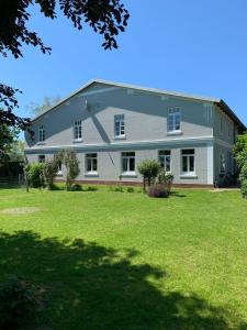 una gran casa blanca con un patio verde en Tjarkshof, en Friedrichskoog