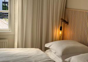 a bedroom with two white beds and a window at Hotel Blomme's Place in Snogebæk