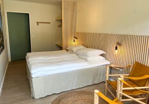 a bedroom with a large bed and a chair and a chair at Hotel Blomme's Place in Snogebæk
