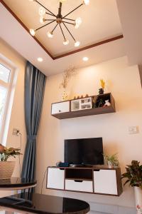 een woonkamer met een tv en een plafond bij Phan Rang City View Homestay in Kinh Dinh