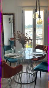 comedor con mesa de cristal y sillas en Apartamento Entrebateas en Aldán