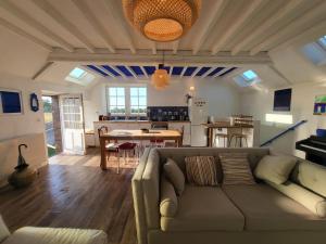 een woonkamer met een bank en een keuken bij Casa Azul - Omaha Beach in Colleville-sur-Mer