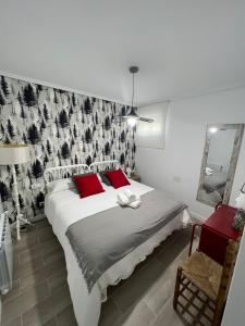 ein Schlafzimmer mit einem großen Bett mit roten Kissen in der Unterkunft Apartamento Entrebateas in Aldán + 1 Foto