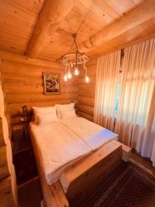 ein Schlafzimmer mit einem Bett in einer Holzhütte in der Unterkunft Brvnara Antika in Veliko Gradište