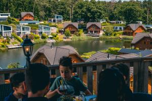 eine Gruppe von Kindern, die auf einer Terrasse sitzen und auf ein Dorf blicken in der Unterkunft EuroParcs Brunssummerheide in Brunssum