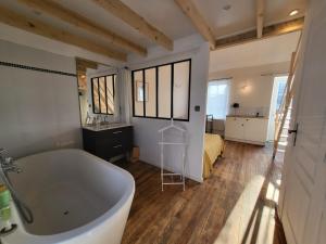 een badkamer met een bad en een slaapkamer met een bed bij Casa Azul - Omaha Beach in Colleville-sur-Mer