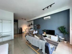 - un salon avec un canapé et un mur bleu dans l'établissement Awesomestay at Arte plus Ampang, à Kuala Lumpur