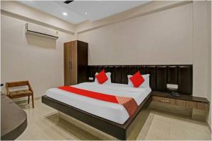 una camera da letto con un grande letto con cuscini rossi di Hotel Four Petals a Bhopal
