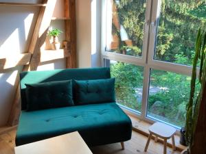 zieloną kanapę w pokoju z dużym oknem w obiekcie Lutki Dom w mieście Lubin
