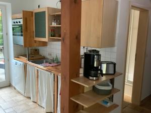a kitchen with wooden cabinets and a coffee maker at Lutki Dom in Lübben