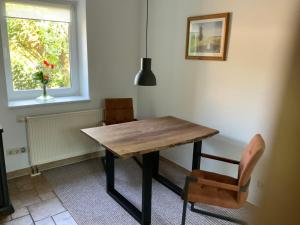 einem Esstisch mit 2 Stühlen und einem Fenster in der Unterkunft Lutki Dom in Lübben
