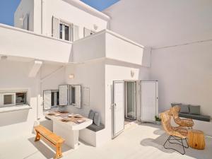 a white living room with a table and chairs at Psathi Beach House in Kimolos