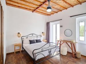 - une chambre avec un lit et un plafond en bois dans l'établissement Psathi Beach House, à Kimolos