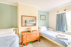 a bedroom with two beds and a mirror and a dresser at The Perks in Scarborough