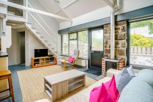 a living room with a couch and a fireplace at Brewery Cottage in Pontfaen