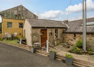 a small stone cottage with a table in front of it at Swaledale Watch Garden Annexe in Wigton