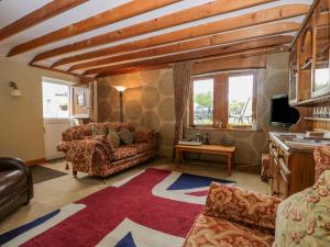 a living room with a couch and a tv at Swaledale Watch Garden Annexe in Wigton