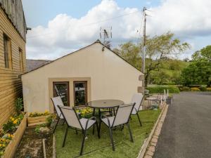 a patio with a table and chairs in front of a building at Swaledale Watch Garden Annexe in Wigton