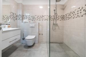 ein Badezimmer mit Toilette und Glasdusche in der Unterkunft Green Point Paklenica in Starigrad-Paklenica + 37 Fotos