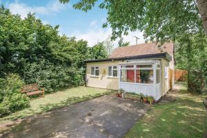 uma pequena casa com uma garagem branca no quintal em Sunshine Lodge em Stolford