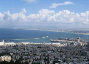 eine Luftansicht auf eine Stadt und das Meer in der Unterkunft Holiday studio apartment near the Bahá ' í gardens in Haifa