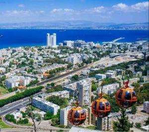 uma cidade com dois orangeospas voando sobre uma cidade em Holiday studio apartment near the Bahá ' í gardens em Haifa