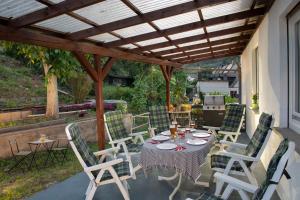 a patio with a table and chairs under a pergola at Ferienwohnung Burgblick Coraidelstein in Klotten +1 photo