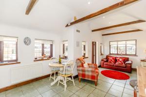 a living room with a red couch and a table at Willow Cottage in Ulrome