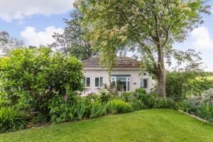 a white house with a garden in front of it at Bracken Barn Cottage in Morpeth