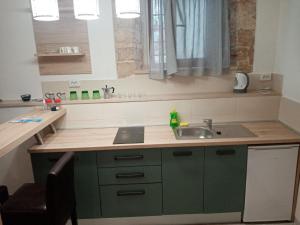 een keuken met groene kasten en een wastafel bij Studio apartment Iva in Bale