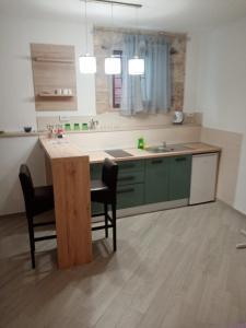 una cocina con armarios verdes, mesa y sillas en Studio apartment Iva, en Bale