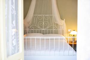 um quarto com uma cama de dossel branca em Al Porticciolo em Nesso
