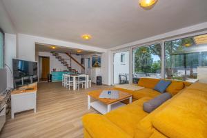 ein Wohnzimmer mit einem gelben Sofa und einem Tisch in der Unterkunft Villa Barbara in Klenovica