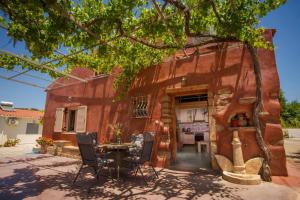 a building with a table and chairs in front of it at Avocado Villa Iason in Chania