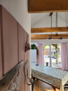 Zimmer mit einem Tisch und einer Tür zu einer Terrasse in der Unterkunft Beautiful barn with private log fired hot tub in Maidstone