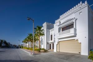 a white house with a garage on a street at Villa Asiana - Exclusive 8-Bedroom Villa with signature Amenities By Luxury Explorers Collection in Dubai