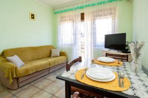 a living room with a couch and a table at Apartments Filosevic by El-Pi Tours in Njivice