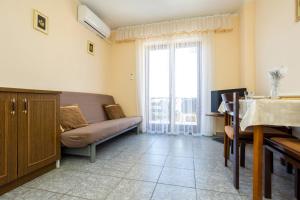 a living room with a couch and a window at Apartments Filosevic by El-Pi Tours in Njivice
