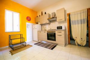 una cucina con pareti gialle e frigorifero bianco di Tiricca Holiday Home a Badesi