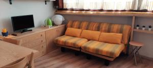 salon z krzesłem i telewizorem w obiekcie Condominio Escargot w mieście Breuil-Cervinia