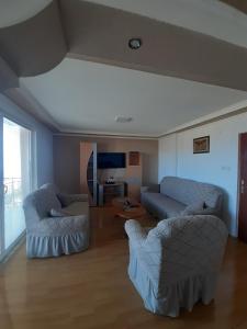 uma sala de estar com duas cadeiras e um sofá em Apartments Stefan Trpejca em Ohrid