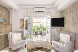 ein Wohnzimmer mit 2 Stühlen und einem Tisch in der Unterkunft Lassani cozy and quiet, 2 bedroom apartm with spacious balcony in Thessaloniki