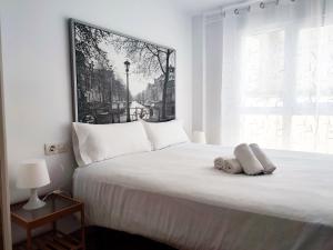 a bedroom with a white bed with a large window at Flats Friends Nave in Valencia