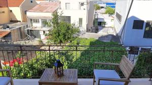 a balcony with a table and chairs and a view of a city at Tasias apartments in Lixouri