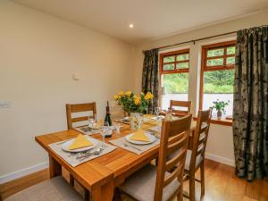 a dining room with a wooden table and chairs at Thistle Dhu in Newtonmore