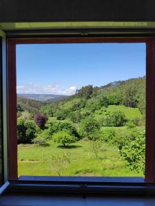 una ventana con vistas a un campo verde en Casa de campo en pleno centro de Asturias, en Sesiello