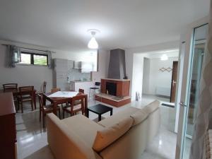 a living room and kitchen with a couch and a table at Casa degli Ulivi con parcheggio privato in Muro Lucano